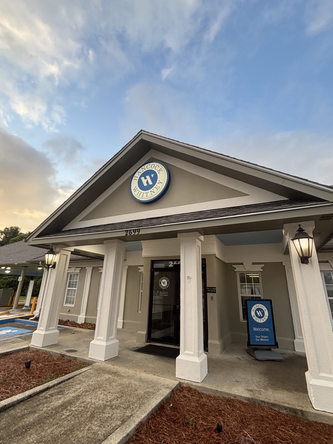 Finished Hancock Whitney bank entrance with freshly painted columns and exterior trim