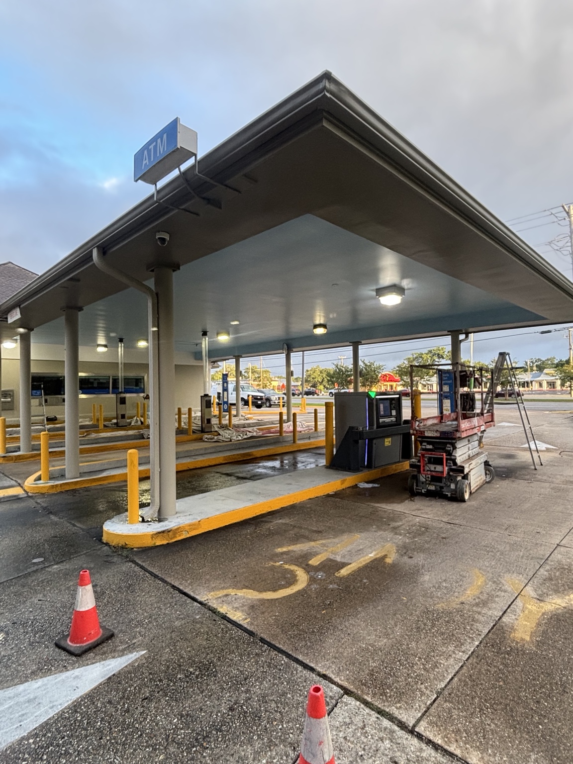 Commercial bank drive-through painting in progress using a lift